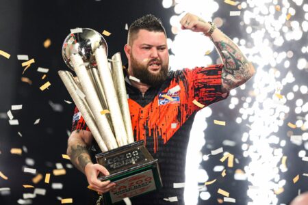 Michael Smith celebrates with the World Darts Championship trophy.