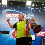 Michael van Gerwen celebrating on stage while holding the World Matchplay darts trophy in Blackpool.