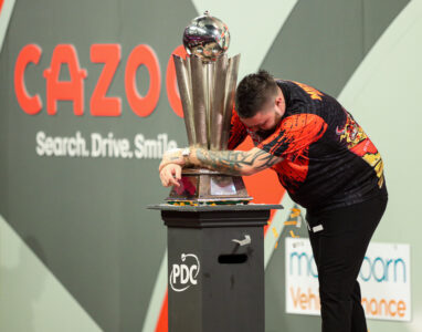 Michael Smith hugs the World Darts Championship trophy.