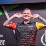 Mike de Decker on stage playing darts