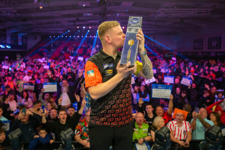 Mike De Decker kisses the World Grand Prix trophy as the crowd look on