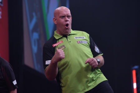 Michael van Gerwen celebrates on stage playing darts.