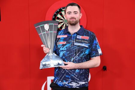 Luke Humphries holding the 2024 Players Championship Finals trophy.